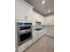 Modern kitchen with white cabinetry, stainless steel appliances, and tile backsplash at 17122 Moonflower Dr, Venice, FL 34293