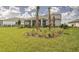 Expansive backyard with lush lawn, ornamental grasses, and young palm trees, enhancing curb appeal at 17146 Moonflower Dr, Venice, FL 34293
