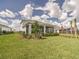 Well-manicured backyard featuring a screened lanai, manicured landscaping, and a spacious lawn at 17146 Moonflower Dr, Venice, FL 34293