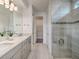 Modern bathroom with double vanity, walk-in shower featuring glass enclosure and tiled walls at 17146 Moonflower Dr, Venice, FL 34293