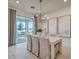 Open dining space with a white table, chandelier, modern art, and sliding glass doors to the outdoor area at 17146 Moonflower Dr, Venice, FL 34293