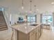 Open-concept kitchen with island seating, stainless steel appliances, and a view into the living room at 17146 Moonflower Dr, Venice, FL 34293