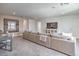 Spacious living room with large sectional sofa, media center, and neutral tones at 17146 Moonflower Dr, Venice, FL 34293