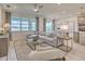 Spacious living room with large windows, neutral decor, and views of the lake and the stylish kitchen at 17146 Moonflower Dr, Venice, FL 34293