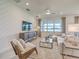 Bright living room with textured accent wall, large windows overlooking the water, and cozy furniture at 17146 Moonflower Dr, Venice, FL 34293