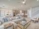 Open-concept living space with a cozy sectional sofa, modern kitchen, and staircase leading to the second floor at 17146 Moonflower Dr, Venice, FL 34293