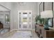 Bright foyer with a decorative door, wooden floors, and a stylish console table with a mirror at 17466 Nokota Ave, Hudson, FL 34667
