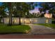 Charming single-story home with mature landscaping and a brick driveway at dusk at 1800 Mound S Pl, St Petersburg, FL 33712