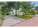 Attractive home exterior featuring a lush green lawn and brick driveway at 1800 Mound S Pl, St Petersburg, FL 33712