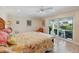 Bright bedroom boasts a ceiling fan, tile floors, and sliding glass doors to an outdoor living space and canal at 1939 Hawaii Ne Ave, St Petersburg, FL 33703