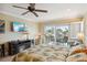 Bright bedroom boasts a ceiling fan, TV, and sliding glass doors to a balcony at 1939 Hawaii Ne Ave, St Petersburg, FL 33703