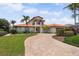 Stunning two-story home featuring a red tile roof and an inviting brick driveway surrounded by lush landscaping at 1939 Hawaii Ne Ave, St Petersburg, FL 33703