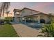 Sunset view of a home exterior with a pool, patio, and outdoor entertaining space at 1939 Hawaii Ne Ave, St Petersburg, FL 33703