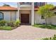 Elegant front entrance featuring beautiful wooden double doors and manicured landscaping along the brick walkway at 1939 Hawaii Ne Ave, St Petersburg, FL 33703