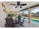 Covered outdoor dining area with a ceiling fan and pool view at 1939 Hawaii Ne Ave, St Petersburg, FL 33703