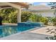 Pool with waterfall feature surrounded by lush landscaping and a tiled patio at 1939 Hawaii Ne Ave, St Petersburg, FL 33703