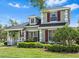 Charming two-story home with lush landscaping, covered porch, and red window shutters at 20053 Heritage Point Dr, Tampa, FL 33647