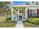 Charming front porch with decorative columns, bench seating, and well-maintained landscaping at 20053 Heritage Point Dr, Tampa, FL 33647