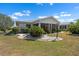 Well-maintained backyard with manicured landscaping and a white house at 204 Cactusflower Ln, Sun City Center, FL 33573