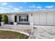 A home with a two-car garage, beautiful landscaping, and a paved walkway to the front door at 204 Cactusflower Ln, Sun City Center, FL 33573