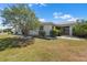 Charming single-story home featuring a well-manicured lawn, mature landscaping, and a screened lanai at 204 Cactusflower Ln, Sun City Center, FL 33573