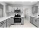 Updated kitchen featuring stainless steel appliances, gray cabinets, and white countertops at 204 Cactusflower Ln, Sun City Center, FL 33573