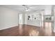 Open-concept living room featuring hardwood floors and a view into the kitchen with modern, white cabinets at 204 Cactusflower Ln, Sun City Center, FL 33573