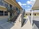 Exterior view featuring concrete stairs leading to the second-story units, framed by black iron railings at 2501 Harn Blvd # H39, Clearwater, FL 33764