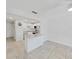 Bright, open-concept living space with tiled floors, breakfast bar and a view into the kitchen at 2501 Harn Blvd # H39, Clearwater, FL 33764