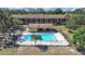 An aerial view reveals a gated in-ground pool and multi-Gathering residential building with lush greenery at 2501 Harn Blvd # H39, Clearwater, FL 33764