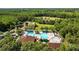 A beautiful community pool with a clubhouse, tennis courts, and playground surrounded by mature trees at 25304 Lexington Oaks Blvd, Wesley Chapel, FL 33544