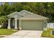 Charming single-story home featuring a well-manicured lawn, two-car garage, and neutral-toned exterior at 25304 Lexington Oaks Blvd, Wesley Chapel, FL 33544