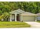 Charming single-story home featuring a well-manicured lawn, two-car garage, and neutral-toned exterior at 25304 Lexington Oaks Blvd, Wesley Chapel, FL 33544