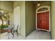 Cozy front porch with seating and a view of the red front door at 25304 Lexington Oaks Blvd, Wesley Chapel, FL 33544