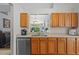 Bright kitchen with oak cabinets, stainless steel dishwasher, and view to the living room at 25304 Lexington Oaks Blvd, Wesley Chapel, FL 33544