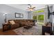 Comfortable living room features a plush sectional, ceiling fan, and sliding glass door at 25304 Lexington Oaks Blvd, Wesley Chapel, FL 33544