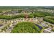 Aerial view of a lush neighborhood featuring beautiful homes, serene lakes, and green landscapes at 25304 Lexington Oaks Blvd, Wesley Chapel, FL 33544