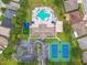 Aerial view showcasing a community pool, tennis courts, clubhouse, parking and green spaces amongst surrounding homes at 2611 Eagle Crest Ct, Holiday, FL 34691