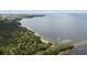 Stunning aerial view of the lush green landscape meets the serene bay waters at 2611 Eagle Crest Ct, Holiday, FL 34691