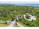 Aerial perspective of trails, wooded land, entrance road and distant bay waters at 2611 Eagle Crest Ct, Holiday, FL 34691