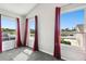 Bright bedroom featuring a gray carpet, three large windows, and red curtains at 2611 Eagle Crest Ct, Holiday, FL 34691