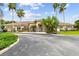 Elegant clubhouse exterior featuring lush tropical landscaping, stone accents and a welcoming entrance at 2611 Eagle Crest Ct, Holiday, FL 34691