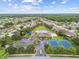 Aerial view of a community featuring a pool, tennis courts, parking, and playground surrounded by homes and trees at 2611 Eagle Crest Ct, Holiday, FL 34691