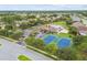 Aerial view of a community with a pool, tennis courts, parking, playground, and green spaces among the homes at 2611 Eagle Crest Ct, Holiday, FL 34691