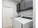 Laundry room with front load washer, front load dryer, and upper storage cabinets at 2611 Eagle Crest Ct, Holiday, FL 34691