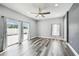 Bright living room features wood floors, sliding glass doors to the outside, and a ceiling fan at 2611 Eagle Crest Ct, Holiday, FL 34691