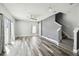 Open living room area with wood-look floors, neutral paint, a ceiling fan, and staircase to the upper level at 2611 Eagle Crest Ct, Holiday, FL 34691