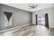 Main bedroom featuring hardwood floors, large window, ceiling fan, and neutral paint at 2611 Eagle Crest Ct, Holiday, FL 34691