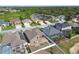 Aerial view of a neighborhood featuring a variety of homes, some with screened-in pools, near a pond and wooded area at 2611 Eagle Crest Ct, Holiday, FL 34691