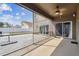 Spacious screened-in patio with a ceiling fan, leading to a paved backyard area at 2611 Eagle Crest Ct, Holiday, FL 34691